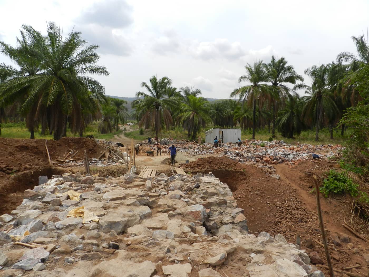Stone delivered and stockpiled on the approach road at Nyamihanga